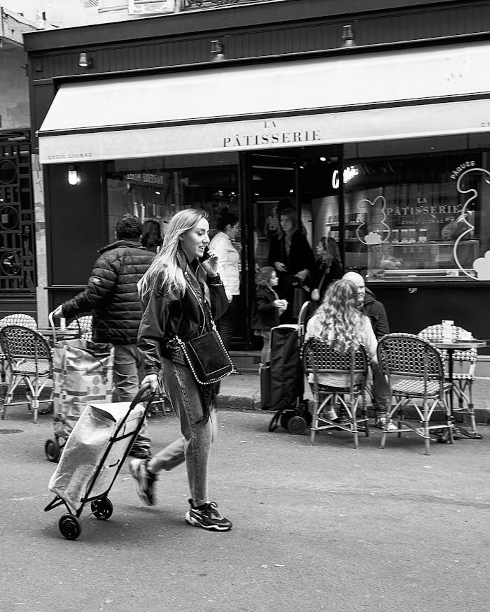 our-services-03 Black and white photo of people walking past a Parisian cafe, capturing everyday life in the city.